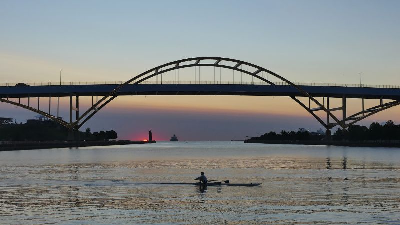 kayaker on lake michigan under bridge