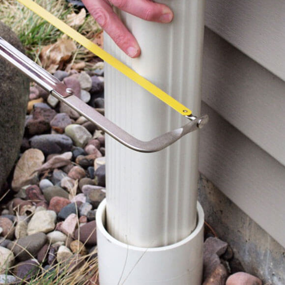 man cutting downspout